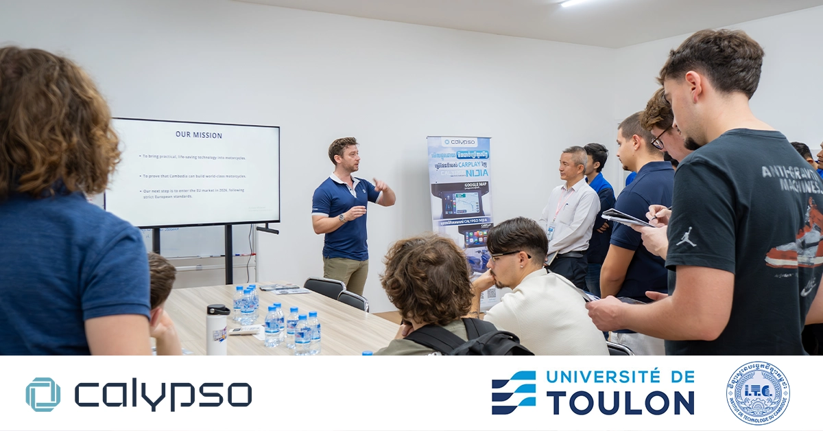 Students and professors from ITC and Université de Toulon sitting in the meeting room, listening to Mr. Bastien, the General Manager of Calypso Motors, presenting the company profile before the factory tour. Calypso, ITC, and Toulon logos are visible in the image.